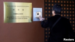 FILE - Seorang jurnalis dari Korea Selatan menekan interkom kedutaan Korea Utara di Madrid, Spanyol, 28 Februari 2019. (REUTERS/Sergio Perez). Pyongyang telah menutup menutup misi diplomatiknya di Hong Kong dan Spanyol, minggu lalu.