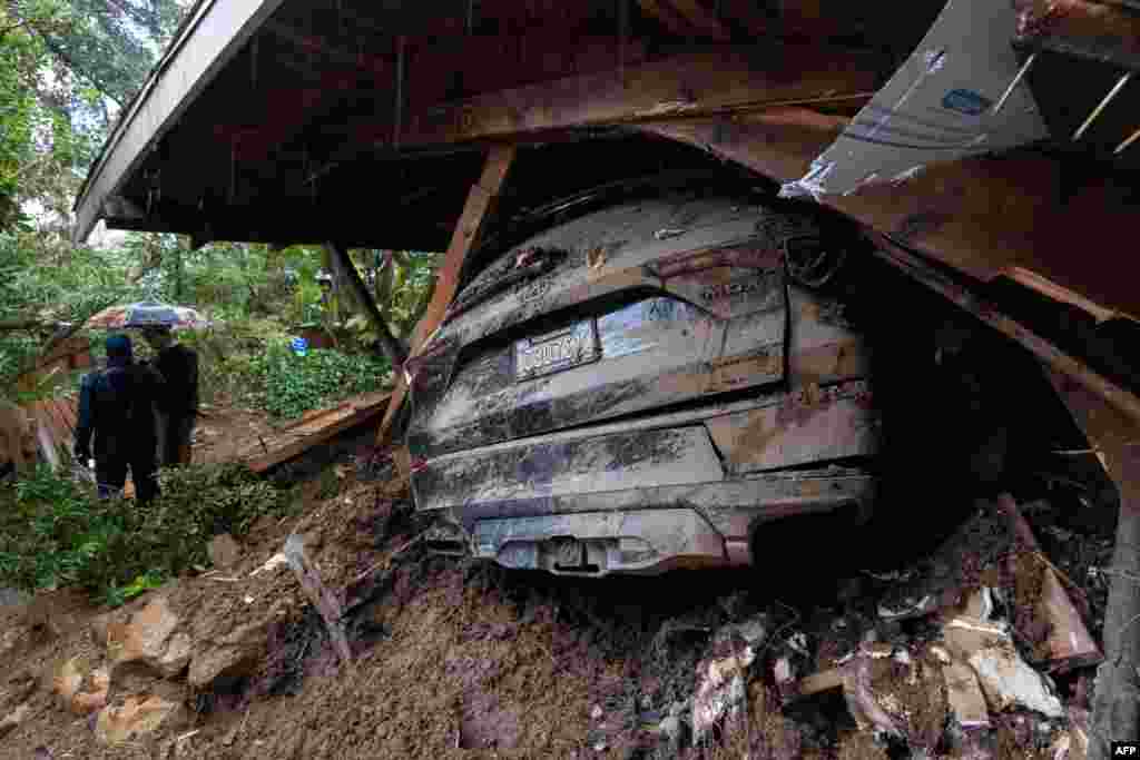 A car remains in the wreckage after a house and garage were destroyed by a landslide as a historic atmospheric river storm inundates the Hollywood Hills area of Los Angeles, California, Feb. 6, 2024.