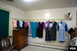 Una habitación de un matrimonio Amish no tiene apenas muebles. Las mujeres cuelgan en la pared su vestidos largos y de sobrios colores. Lancaster, Pensilvania, Estados Unidos. [Fotografía: Ismael Rodríguez/VOA]