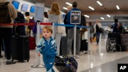 I njemu se žuri na avion - dečak vuče kofer na aerodromu u Nešvilu (Foto: AP/George Walker IV)