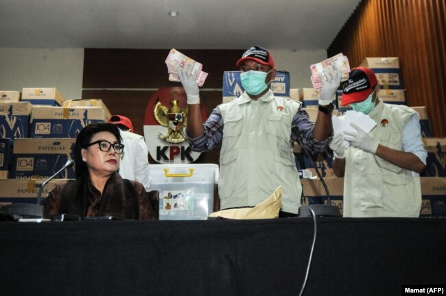 Deputi Komisi Pemberantasan Korupsi (KPK) Basariah Panjaitan (kiri) bersama petugas KPK menunjukkan tumpukan uang miliaran rupiah yang disita dari kantor seorang anggota DPR, 28 Maret 2019. (Foto: Mamat/AFP)
