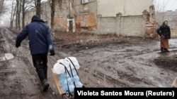 (FILE) A resident walks with water bottles as their town in Ukraine remains without water after a Russian attack on critical infrastructure.