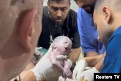 A medic holds a Palestinian newborn after she was pulled alive from the womb of her mother who was killed in an Israeli strike in Rafah in the southern Gaza Strip in this still image taken from a video recorded April 20, 2024. (Reuters TV via Reuters)