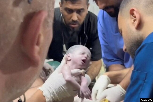 Petugas medis menggendong bayi perempuan Palestina yang baru lahir setelah dikeluarkan hidup-hidup dari rahim ibunya yang terbunuh dalam pemboman Israel di Rafah di Jalur Gaza selatan, Sabtu malam (20/4).