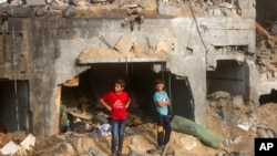 Palestinski dečaci ispred zgrade u Kan Junisu (Foto: AP/Mohammed Dahman)