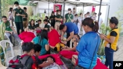 In this handout photo provided by the Philippine Red Cross, volunteers attend to people affected by an earthquake that struck General Santos City, South Cotabato, southern Philippines, Nov. 17, 2023.