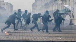 Protesters shield with umbrellas as they scuffle with riot police during rally in Nantes, western France, March 23, 2023. 