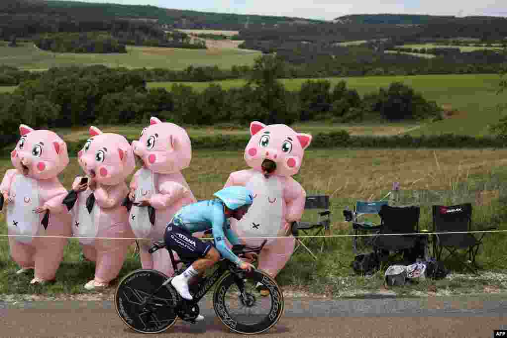 Astana Qazaqstan Team's British rider Mark Cavendish cycles past spectators in inflatable costumes during the 7th stage of the 111th edition of the Tour de France cycling race, between Nuits-Saint-Georges and Gevrey-Chambertin.