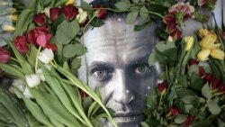 Bunga-bunga di sekitar potret pemimpin oposisi Rusia yang sudah meninggal, Alexey Navalny, di sebuah tugu sementara di depan bekas konsulat Rusia di Frankfurt am Main, Jerman, pada 19 Februari 2024. (Foto: AFP)