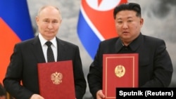 俄罗斯总统普京与朝鲜领导人金正恩在平壤举行的签字仪式上合影。（2024年6月19日）