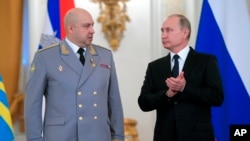 FILE - Russian President Vladimir Putin, right, applauds Col. Gen. Sergei Surovikin during an awards ceremony for troops who fought in Syria, in the Kremlin, in Moscow, Dec. 28, 2017.