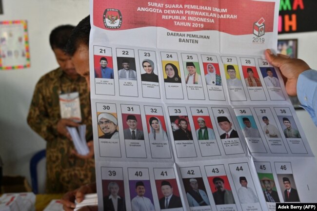 Saksi dari partai-partai peserta pemilu ikut memeriksa surat suara di TPS di Jakarta pada 17 April 2019. (Foto: ADEK BERRY/AFP)