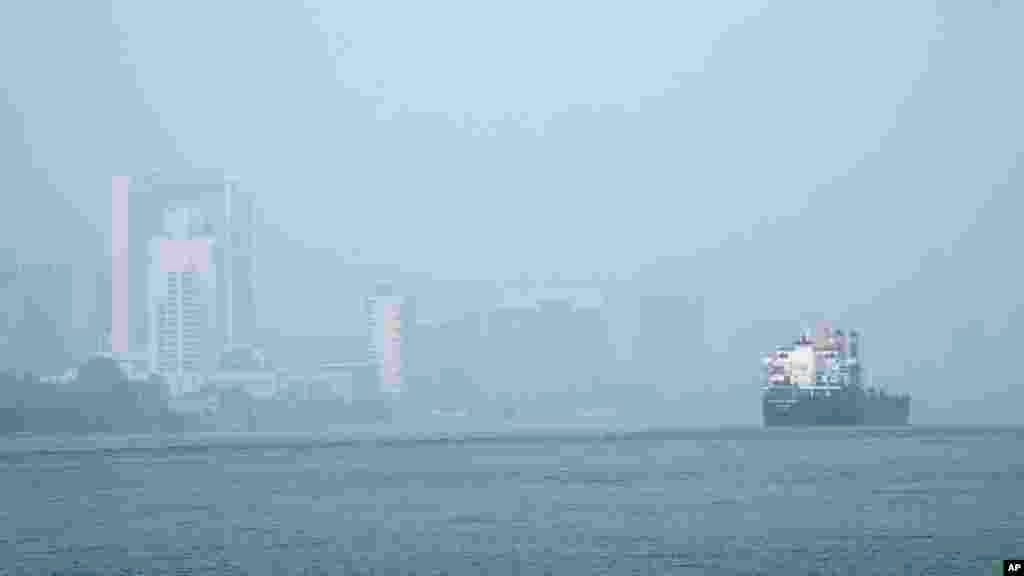 A freighter passes through the Detroit River as smoke fills the sky reducing visibility to Windsor, Ontario, Canada, as seen from Detroit.