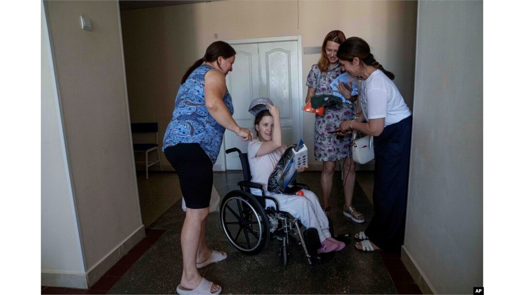 Oksana Femeniuk, left, and her daughter Solomiia receive presents from volunteers, a day after they survived a Russian missile strike on Okhmatdyt children's hospital, in Kyiv, Ukraine, July 9, 2024.