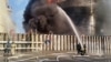 Petugas Rusia sedang berupaya memadamkan api di tangki penyimpanan minyak setelah dugaan serangan pesawat tak berawak di Kota Azov di wilayah selatan Rostov, Rusia, 18 Juni 2024. (Foto: via Reuters)