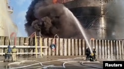 Tim pemadam kebakaran berupaya memadamkan api di tangki penyimpanan minyak setelah dugaan serangan pesawat tak berawak di kota Azov, wilayah selatan Rostov, Rusia, 18 Juni 2024, dalam gambar diam yang diambil dari video. (Kementerian Keadaan Darurat Rusia/Handout via REUTERS)
