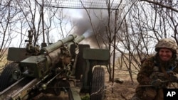 資料照片：一名烏軍在烏克蘭盧甘斯克州克雷米納附近用榴彈砲轟擊俄軍陣地。(2023年4月5日)