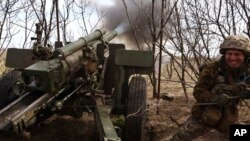 A Ukrainian soldier fires a howitzer at Russian positions near Kremenna, Luhansk region, Ukraine, April 5, 2023. U.S. officials are racing to remove leaked documents related to the war from social media platforms.