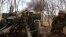 A Ukrainian soldier fires a howitzer at Russian positions near Kremenna, Luhansk region, Ukraine, April 5, 2023. U.S. officials are racing to remove leaked documents related to the war from social media platforms.