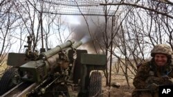 A Ukrainian soldier fires a howitzer at Russian positions near Kremenna, Luhansk region, Ukraine, April 5, 2023. U.S. officials are racing to remove leaked documents related to the war from social media platforms.