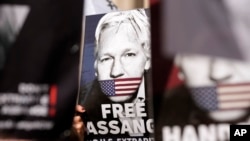 FILE - Protesters hold placards in support of WikiLeaks founder Julian Assange outside the High Court in London, May 20, 2024.