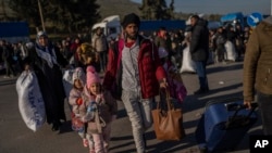 FILE - Syrians cross into their country from the Turkish crossing point of Cilvegozu, in Reyhanli, southeastern Turkey, on Feb. 18, 2023. 