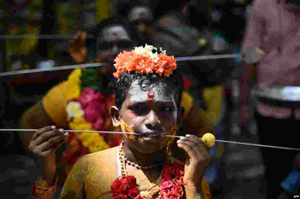 Devotees pierced their cheeks with a metal rod&nbsp; take part in a religious procession to celebrate Aadi festival in Chennai, India.