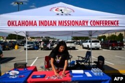 Codie Horse-Topetchy, mahasiswa universitas Oklahoma dan koordinator Rock the Native Vote, mengatur kiosnya di pekan raya Comanche Nation di Lawton, Oklahoma, 30 September 2023. (CHANDAN KHANNA / AFP)