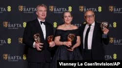 From left, director Christopher Nolan and producers Emma Thomas and Charles Roven, winners of the best film award for 'Oppenheimer', pose for photos at the 77th British Academy Film Awards, in London, Feb. 18, 2024. (Photo by Vianney Le Caer/Invision/AP)