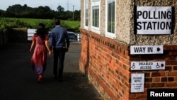 British Prime Minister Rishi Sunak and his wife, Akshata Murty, walk outside a polling station during the general election in Northallerton, Britain, July 4, 2024.