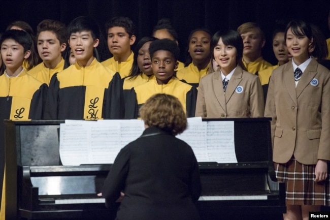 FILE - Choir students from Lincoln High School in Tacoma, Wash., sing with choir students from Tacoma's sister city, Fuzhou, during a performance for Chinese President Xi Jinping during his visit to Tacoma's Lincoln High School, Sept. 23, 2015.