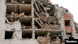 在烏克蘭切爾尼戈夫，救援人員在俄羅斯飛彈襲擊中被摧毀的建築物現場工作。 （2024年4月17日）