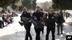 FILE- Israeli police detain a Palestinian in the Al-Aqsa Mosque compound following a raid of the site in Jerusalem during the Muslim holy month of Ramadan, Apr. 5, 2023.