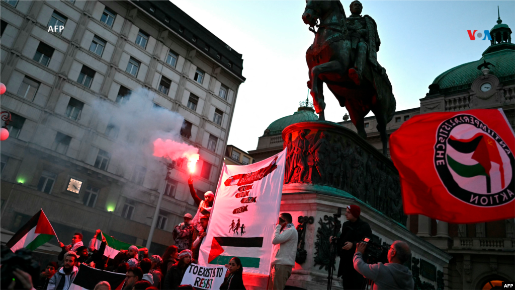 Manifestantes sostienen bengalas y banderas palestinas en Belgrado, Serbia, como apoyo al pueblo palestino en medio del conflicto entre Israel y Hamás.