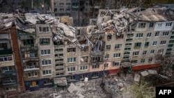 This aerial view shows rescuers on top of a partially destroyed residential building, after a shelling in Sloviansk, Ukraine, April 14, 2023.