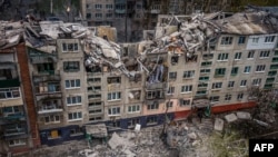 This aerial view shows rescuers on top of a partially destroyed residential building, after a shelling in Sloviansk, amid Russia's military invasion on Ukraine.