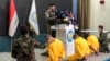 Iraqi Interior Ministry spokesman Moqdad Miri speaks before three blindfolded men during a press conference in Baghdad, July 1, 2024. Miri announced the arrest of three men accused of arson attacks in the country's north.