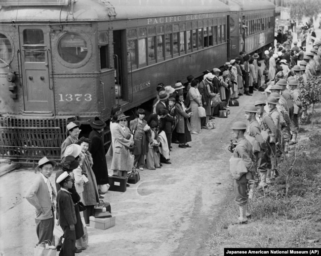 FILE - In this photo provided by the National Archives, Japanese Americans from San Pedro, Calif., arrive at the Santa Anita Assembly Center in Arcadia, California, April 5, 1942.