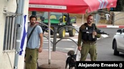 Dos soldados montan guardia en la entrada del kibutz Dafna, en el norte de Israel, muy cerca de la frontera con Líbano, el 31 de octubre de 2023.