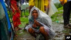 A woman wails after her family members are trapped under rubble from a landslide that washed away houses in the Raigad district, western Maharashtra state, India.
