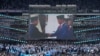 Foto Presiden Joko Widodo (kanan), berjabat tangan dengan Menteri Pertahanan dan calon presiden Prabowo Subianto, ditampilkan di layar lebar saat kampanye di Stadion Utama Gelora Bung Karno di Jakarta, Sabtu, 10 Februari 2024. (AP/Dita Alangkara)