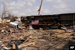 An American flag is seen on an overturned vehicle in Rolling Fork, Mississippi, March 31, 2023, after a deadly tornado and severe storm moved through the area.