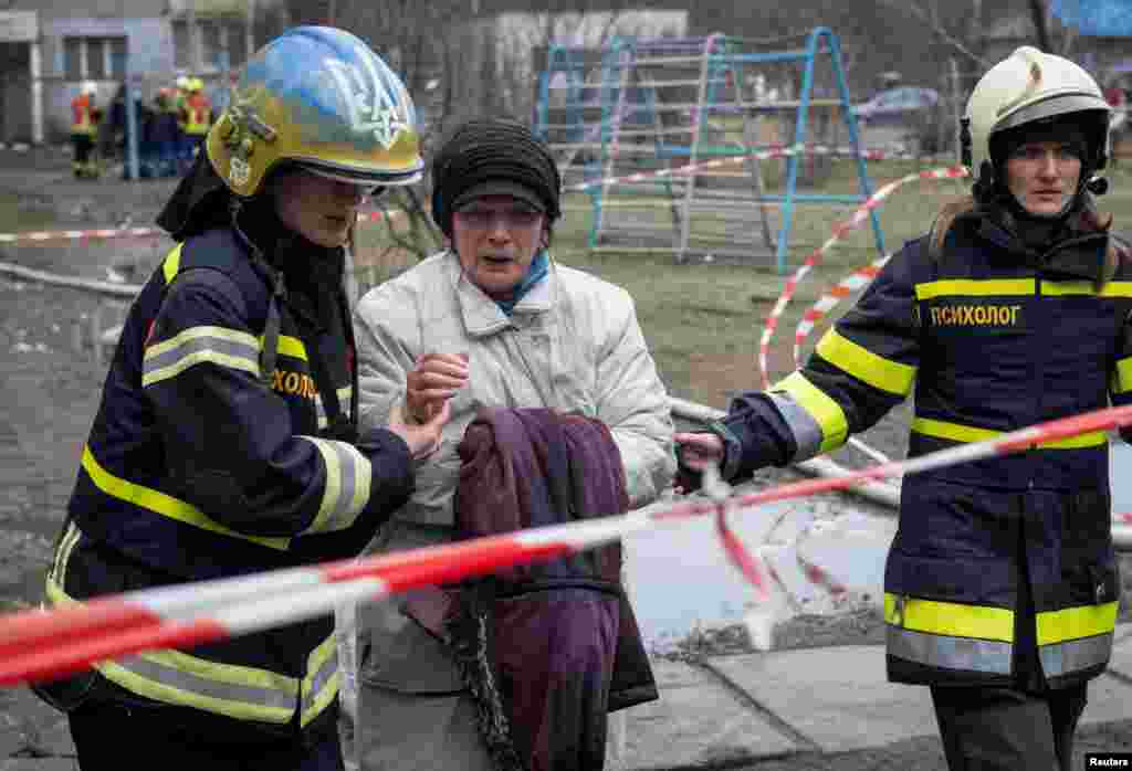 Рятувальники допомагають місцевій мешканці покинути її житловий будинок, пошкоджений під час російського ракетного удару в Києві.&nbsp;Фото&nbsp;REUTERS/&nbsp;Данило Антонюк,&nbsp;7 лютого, 2024 року &nbsp;