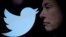 FILE - Twitter logo and a photo of Elon Musk are displayed through magnifier in this illustration taken Oct. 27, 2022. Musk said, July 23, 2023 that he was looking to change Twitter's logo.