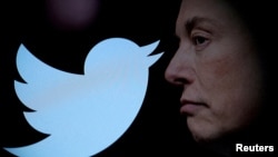 FILE - Twitter logo and a photo of Elon Musk are displayed through magnifier in this illustration taken Oct. 27, 2022.