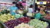FILE - People buy fruit at a stall in Taipei, Taiwan, Sept. 20, 2021. 