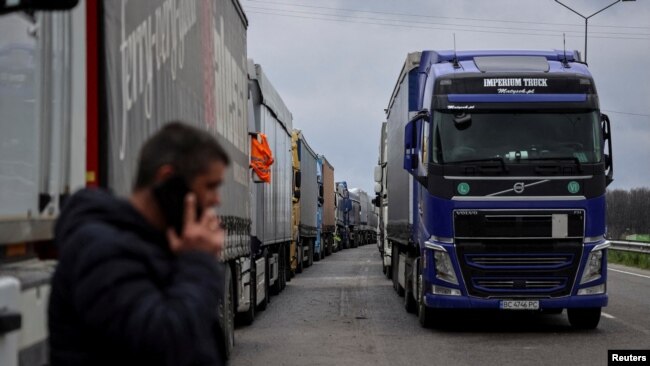 FILE - Trucks wait to cross the Ukraine-Poland border, as Russia's attack on Ukraine continues, at the checkpoint Rava-Ruska, Lviv region, Ukraine, April 17, 2023.