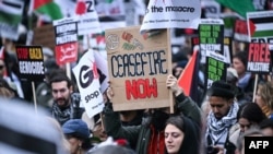 Aktivis pro-Palestina dan sejumlah demonstran lainnya membawa poster berisi seruan gencatan senjata dalam aksi mendukung Palestina di London pada 17 Februari 2024. (Foto: AFP/Justin Tallis)