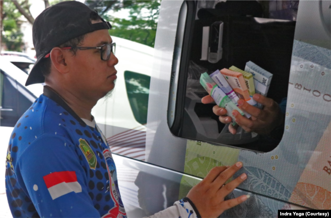 Warga mendapat penjelasan mengenai Cinta, Bangga dan Paham mengenai uang Rupiah dari petugas yang melayani pertukaran uang pecahan kecil di GBK, Jakarta Pusat pada Minggu (9/4). (Foto: VOA/Indra Yoga)