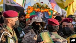 Fighters from the Popular Mobilization Forces carry the coffin of a commander from the Kataib Hezbollah paramilitary group, Wissam Muhammad Sabir Al-Saadi, who was killed in a US airstrike, in Baghdad, Iraq, Feb. 8, 2024.